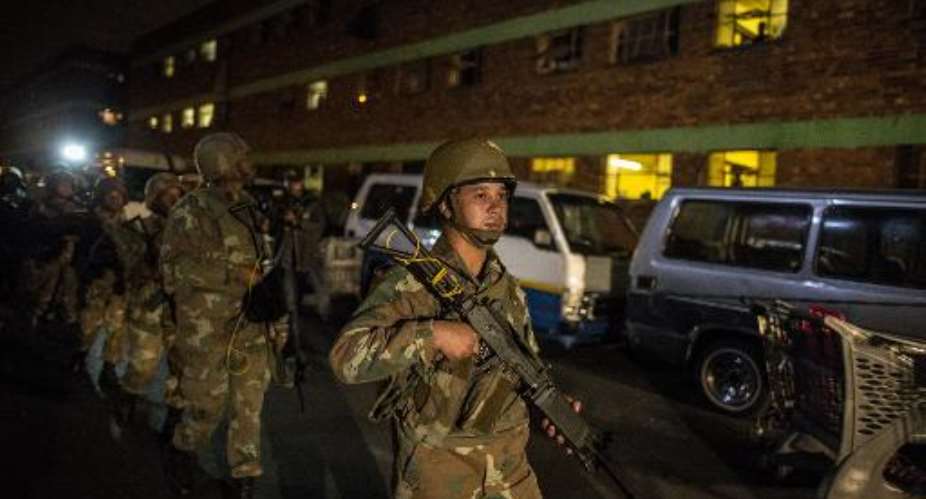 South African Army soldiers leave the suburb of Jeppestown at the end of a joint police and army raid in Johannesburg on April 21, 2015.  By Marco Longari AFP