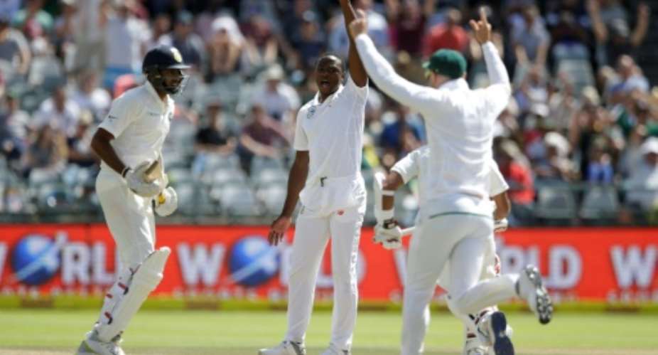 South African bowler Kagiso Rabada centre celebrates the dismissal of Indian batsman Wriddhiman Saha during their fourth day of the first Test match in Cape Town, on January 8, 2018.  By GIANLUIGI GUERCIA AFP