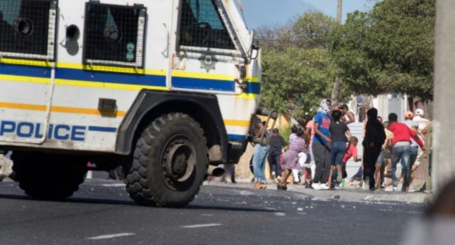 South African police clashed with Cape Town township residents protesting over access to food aid during a coronavirus lockdown.  By RODGER BOSCH AFP