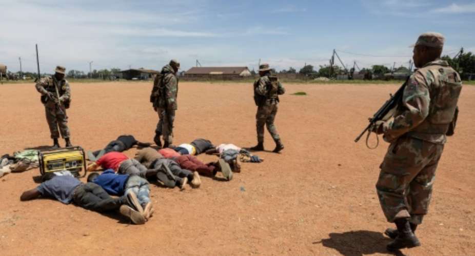 South African soldiers guard detained suspects in the fight against illegal mining in Kagiso, Gauteng Province.  By WIKUS DE WET (AFP/File)