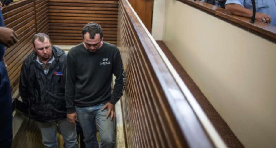 South Africans Willem Oosthuizen L and Theo Martins Jackson R arrive at The Middleburg Magistrate Court on November 16, 2016 during the first hearing of assault charges after an online video emerged showing them pushing a black man into a coffin.  By MUJAHID SAFODIEN AFPFile