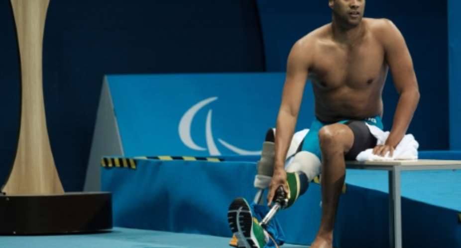 South Africa's Achmat Hassiem puts on his prosthesis after competing a heat of men's 100 m freestyle S10 of the Rio 2016 Paralympic Games on September 13, 2016.  By Yasuyoshi Chiba AFPFile