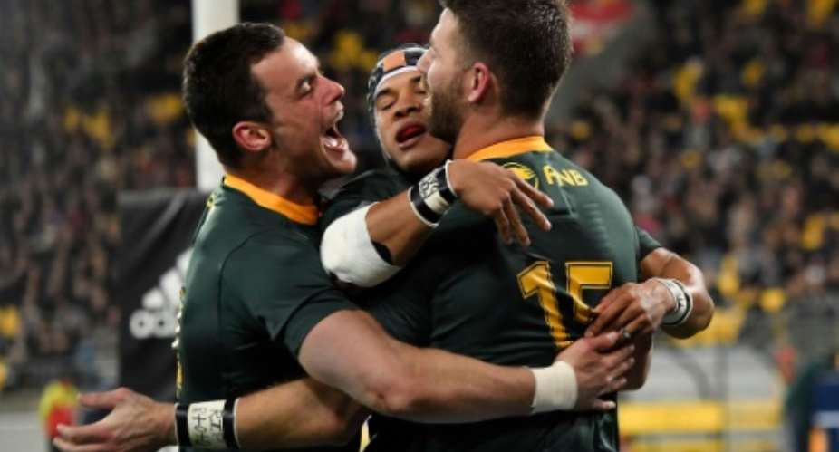 South Africa's Cheslin Kolbe middle celebrates his try Willie le Roux R and Jesse Kriel during the Rugby Championship match against the New Zealand All Blacks at Westpac Stadium in Wellington on September 15, 2018.  By Marty MELVILLE AFP