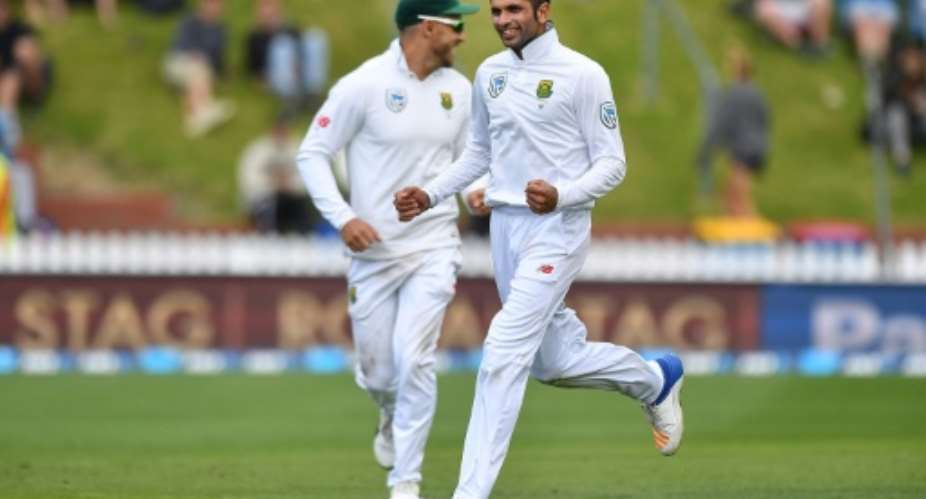 South Africa's Keshav Maharaj R and captain Faf du Plessis celebrate New Zealand's Tim Southee being caught on day three of their second Test match, at the Basin Reserve in Wellington, on March 18, 2017.  By Marty Melville AFP