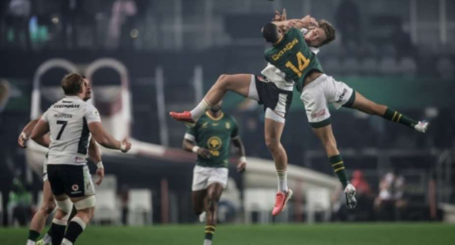 South Africas No. 14 Jaco Williams jumps for the ball against Wales wing Ellis Mee.  By PHILL MAGAKOE (AFP)
