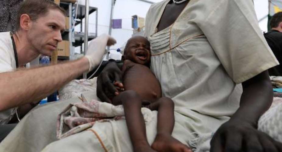 A nine-month-old South Sudanese boy sits on his mother's lap as he receives treatment at a Medecins Sans Frontieres MSF clinic on May 30, 2014 in Malakal.  By Charles Atiki Lomodong AFPFile