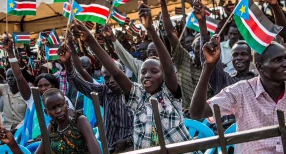 People wave South Sudanese flags during a political rally in Juba, on March 18, 2015.  By Ashley Hamer AFPFile