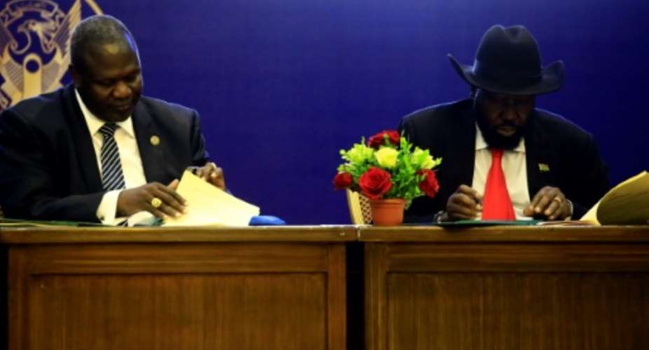 South Sudan President Salva Kiir R and rebel leader Riek Machar sign a power-sharing deal in Khartoum on August 5, 2018.  By ASHRAF SHAZLY AFP