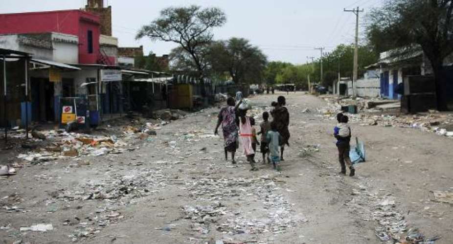 A family walks through a deserted street in Malakal, South Sudan, January 21, 2014.  By Charles Lomodong AFPFile