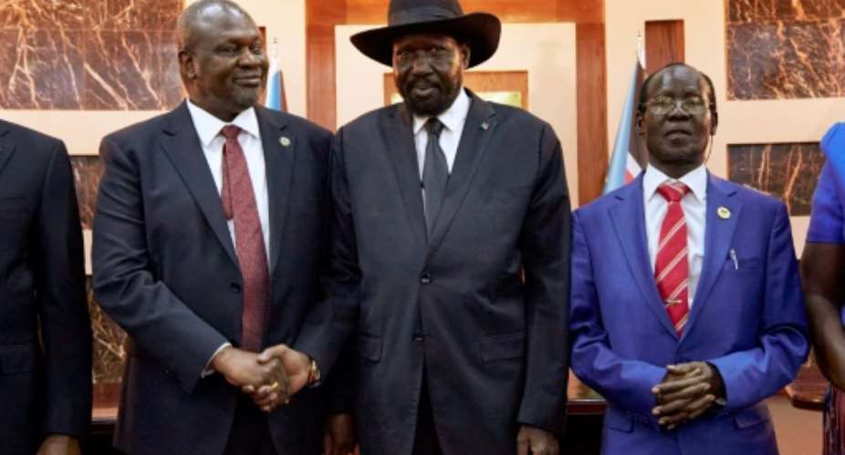 South Sudanese President Salva Kiir C embraced Vice-President Riek Machar L in a step towards peace.  By ALEX MCBRIDE AFP