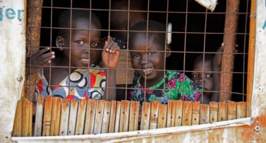 South Sudanese refugee children look through a window at the Nyumanzi transit centre in Adjumani, Uganda on July 13, 2016.  By Isaac Kasamani AFPFile