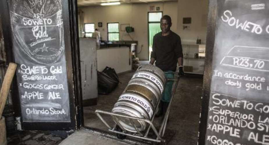 A Soweto Gold craft beer worker pushes beer kegs at the Ubuntu Kraal Brewery on May 13, 2015 in Soweto, Johannesburg.  By Gianluigi Guercia AFP