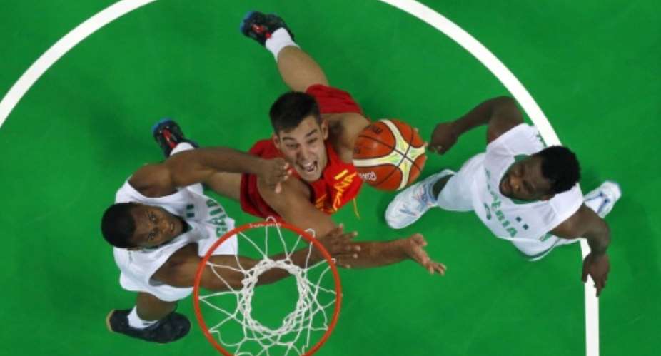 Spains Willy Hernangomez (C) goes for a rebound during an Olympics Group B basketball match against Nigeria in Rio on August 11, 2016.  By Jim Young (Pool/AFP)
