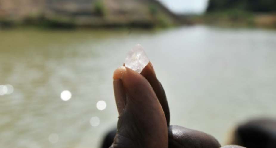 A diamond prospector holds up a diamond stone on April 28, 2012, in Koidu, the capital of the diamond-rich Kono district, in eastern Sierra Leone, on April 28, 2012.  By Issouf Sanogo AFPFile