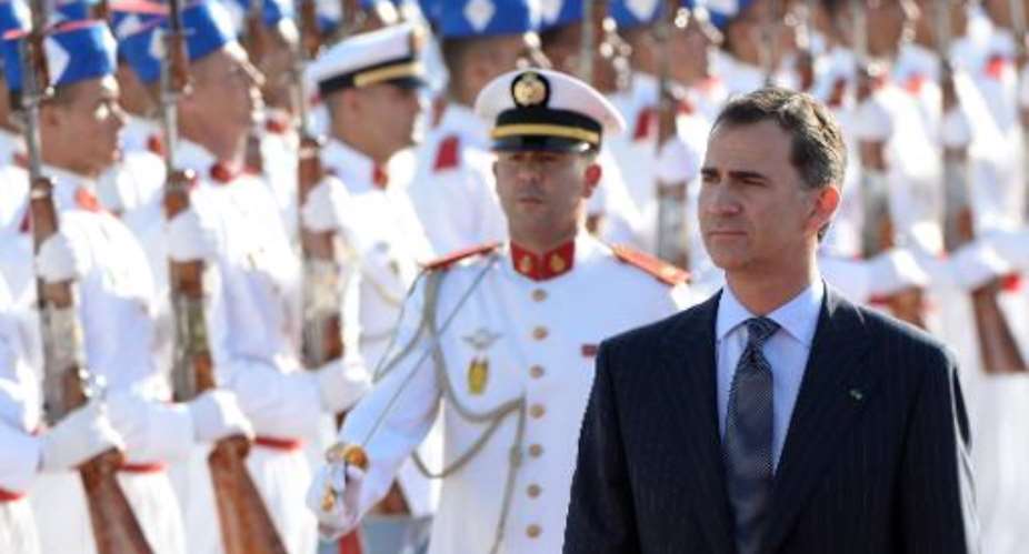 King Felipe VI of Spain stands near Moroccan Royal Guards as he arrives at the airport of Rabat on July 14, 2014.  By Fadel Senna AFP