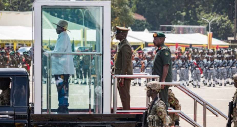 Speculation mounts over who will succeed Ugandan President Yoweri Museveni (L on vehicle).  By BADRU KATUMBA (AFP/File)