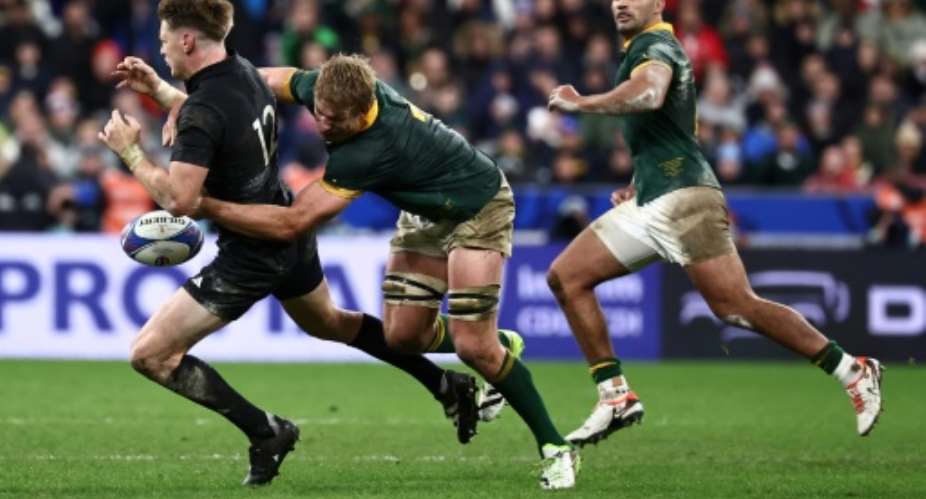 Springbok Pieter-Steph du Toit (C) tackles All Black Jordie Barrett during the 2023 Rugby World Cup final in Paris..  By Anne-Christine POUJOULAT (AFP)