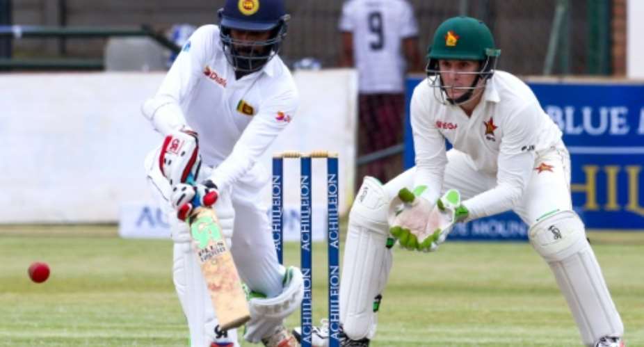 Sri Lanka batsman Upul Tharanga L plays a shot as Zimbabwe's wicketkeeper Peter Moor looks on during the second day's play in the first Test at the Harare Sports Club, on October 30, 2016.  By Jekesai Njikizana AFP