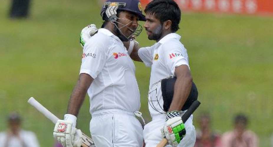 Sri Lanka batsman Niroshan Dickwella R is congratulated by teammate Mahela Jayawardene in Colombo on July 25, 2014.  By Ishara S. Kodikara AFP