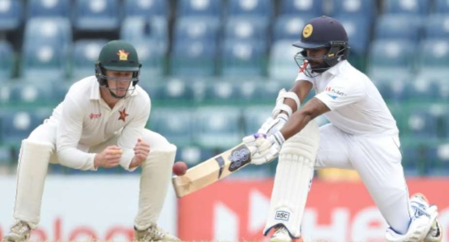 Sri Lanka's Niroshan Dickwella plays a shot as Zimbabwe's Peter Moor looks on during the final day of their one-off Test match at the R Premadasa Cricket Stadium in Colombo on July 18, 2017.  By ISHARA S. KODIKARA AFP