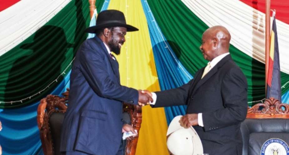 President Salva Kiir left shakes hands with Uganda's President Yoweri Museveni right after signing a peace agreement in Juba, on August 26, 2015.  By Charles Lomodong AFP