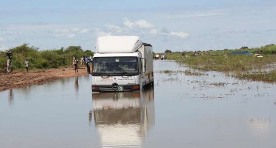 A humanitarian aid truck is stuck in flood waters on October 10, 2014 on Mayom road outside the UNMISS compound accommodating the main internally displaced camp in Bentiu.  By Simon Waakhe Wudu AFP