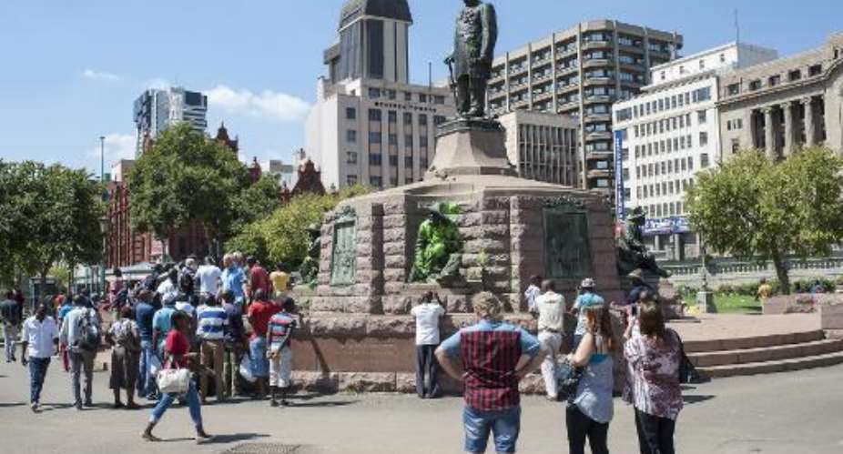 People visit the defaced statue of Paul Kruger in Church Square, Pretoria on April 6, 2015.  By Stefan Heunis AFP