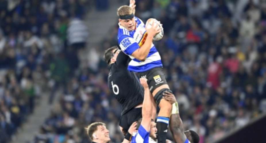 Stormers South African lock Connor Evans gets hold of the ball against New Zealand flanker Simon Parker.  By Rodger Bosch (AFP)