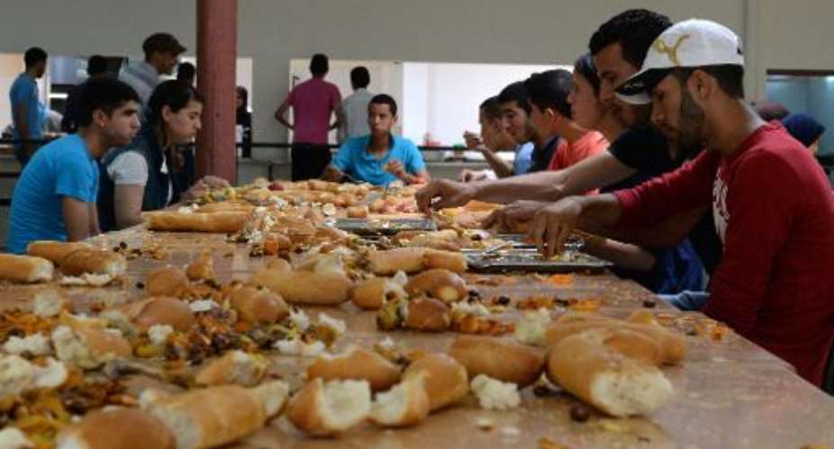 Moroccan students eat on tables covered in leftover food in the cafeteria at the Dhar El-Mehraz campus at the University in Fez, Morocco on May 13, 2014.  By Fadel Senna (AFP/File)