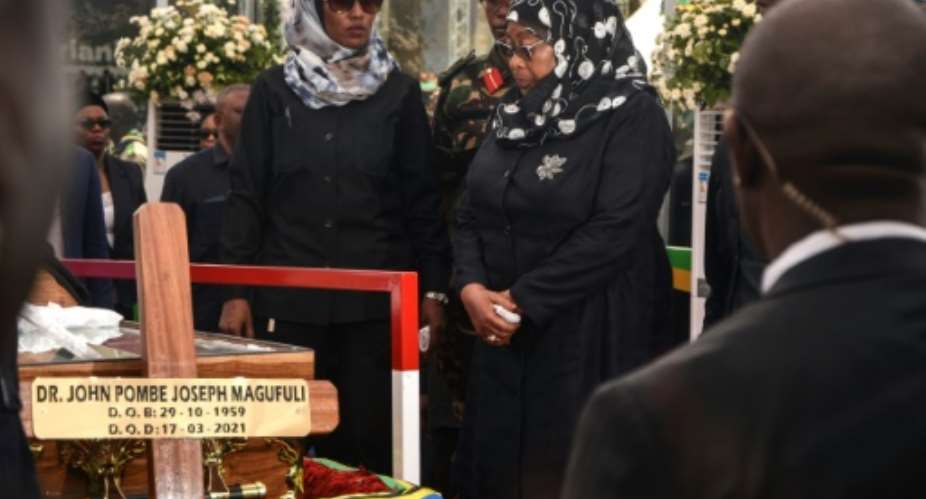 Succession: New Tanzanian President Samia Suluhu Hassan, right, before the coffin of her predecessor, John Magufuli, who died in mysterious circumstances in March.  By STR AFP