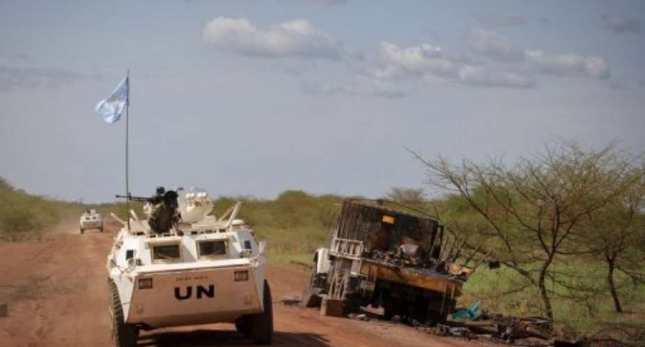 UN peacekeepers drive past a destroyed truck near Abyei.  By Stuart Price AFPUNIMIS