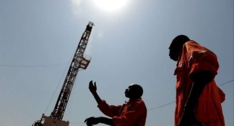 Two workers stand in the Unity oil field in South Sudan.  By Roberto Schmidt AFPFile