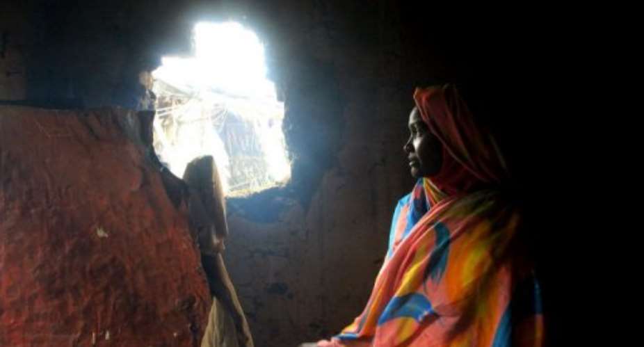 A Sudanese woman shows a hole in her house in Kadugli in the tense border region of South Kordofan on October 21, 2011.  By Ashraf Shazly (AFP/File)