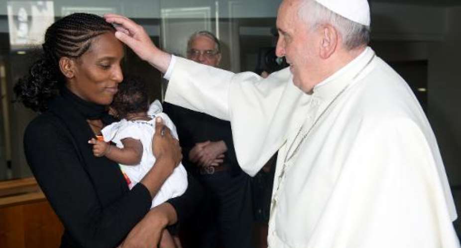 Pope Francis blesses Sudanese Christian Meriam Yahia Ibrahim Ishag and her daughter Maya during a private audience at the Vatican, as shown in this Osservatore Romano photo from July 24, 2014.  By  Osservatore RomanoAFP