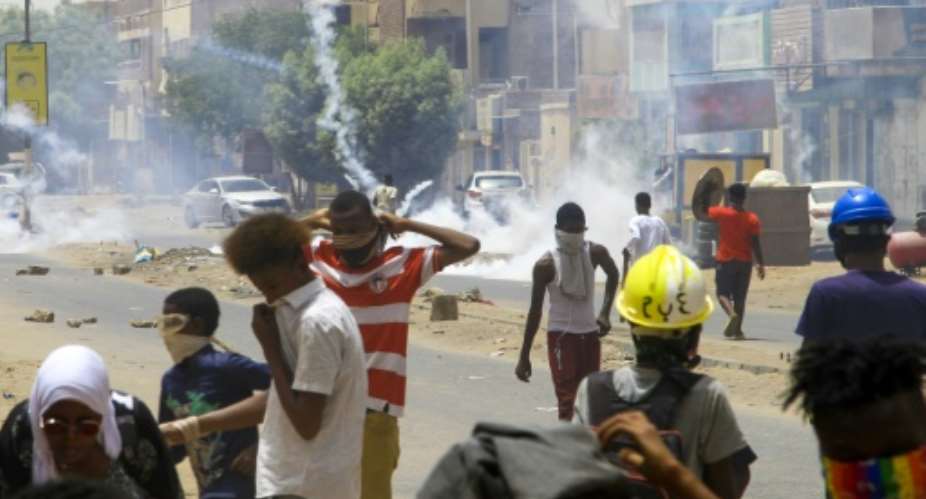 Sudanese demonstrators throw tear gas canisters back at security forces in the capital Khartoum on May 19, 2022, during a demonstration calling for civilian rule.  By - (AFP)