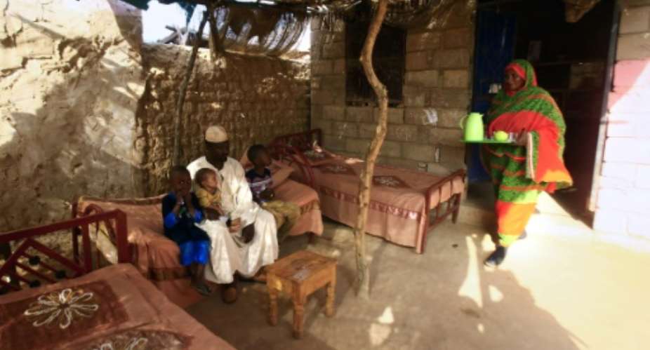 Sudanese engineer Ahmed Abdallah, seated, used to manage his family's expenses on his 400 monthly salary but he has since had to take out loans to make ends meet.  By ASHRAF SHAZLY AFP