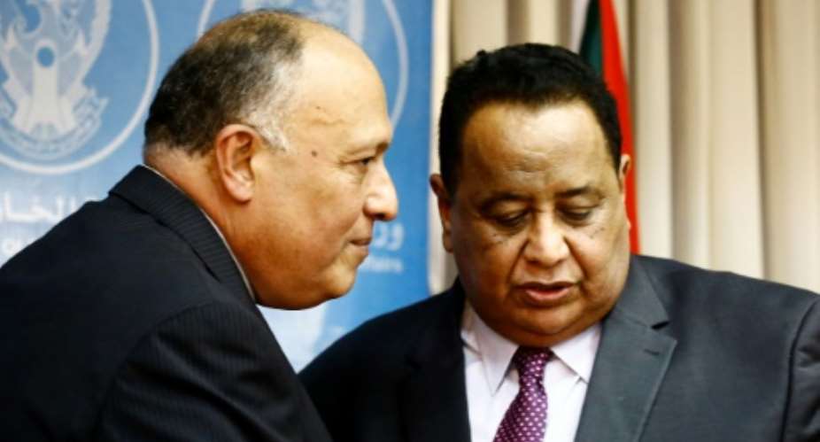 Sudanese Foreign Minister Ibrahim Ghandour R speaks with his Egyptian counterpart Sameh Shokry following a joint press conference in Khartoum on April 20, 2017.  By Ashraf SHAZLY AFP