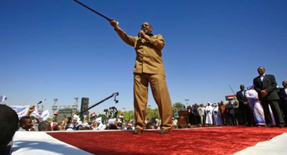 Sudanese President Omar al-Bashir brandished his trademark cane at a loyalist rally in Khartoum, the first in the capital since anti-government protests erupted last month.  By ASHRAF SHAZLY AFP