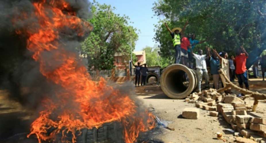 Sudanese protesters block one of Khartoum's main thoroughfares, Nile Street, with burning tyres as they keep up their campaign for civilian rule.  By ASHRAF SHAZLY AFP