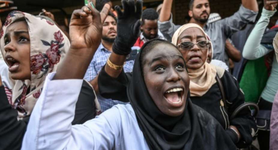Sudanese protesters cheer fellow demonstrators arriving in Khartoum by train.  By OZAN KOSE AFP