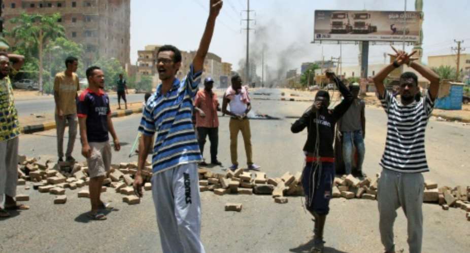 Sudanese protesters gesture and chant slogans outside Khartoum's army headquarters on June 3, 2019 after security forces broke up a weeks-long sit-in, prompting the US to call for an independent and credible investigation into the crackdown.  By Ebrahim Hamid AFPFile