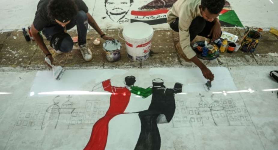Sudanese protesters paint a mural during a sit-in outside the army headquarters in the capital Khartoum on April 28, 2019.  By OZAN KOSE AFP