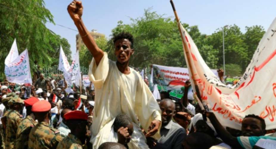 Sudanese protesters take part in a rally demanding the dissolution of the transitional government, outside the presidential palace in Khartoum on Saturday.  By ASHRAF SHAZLY AFP