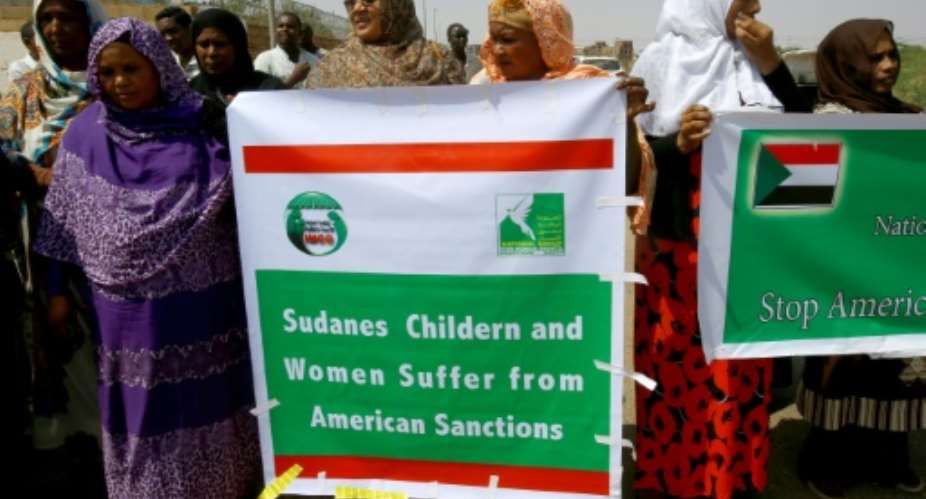 Sudanese representatives of various humanitarian organisations take part in a protest outside the US embassy in Khartoum on September 16, 2015, against the sanctions imposed on the country.  By ASHRAF SHAZLY AFPFile