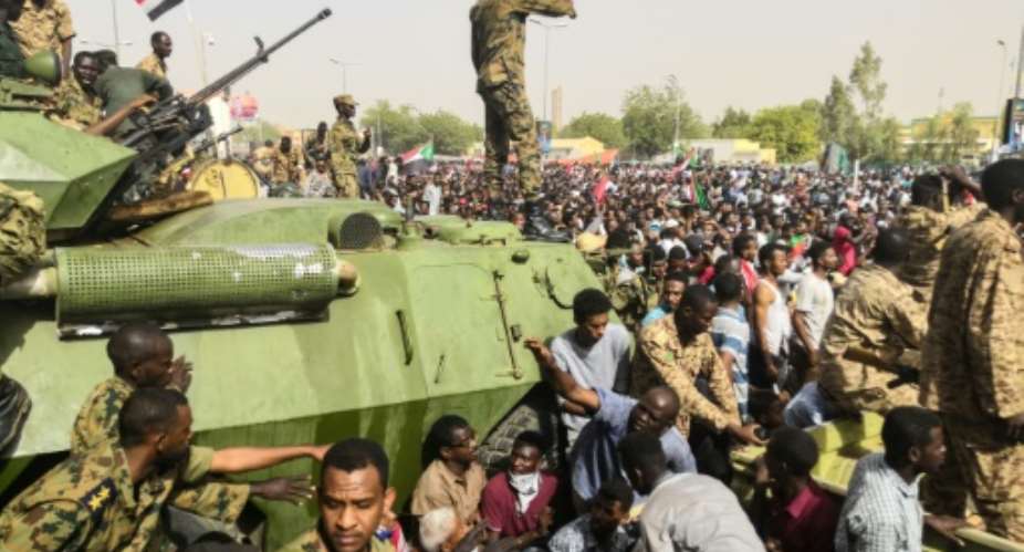 Sudanese soldiers stand guard on armoured military vehicles as demonstrators continue their  protest against the regime near army headquarters in the Sudanese capital Khartoum on April 11, 2019.  By - AFP