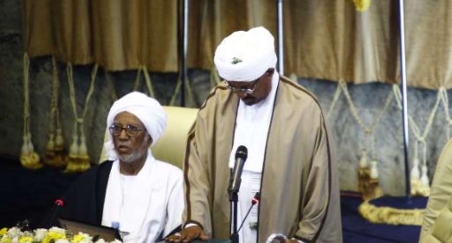 Sudanese President Omar al-Bashir R puts his hand on a copy of the Koran, during his swearing in ceremony for another term of five years at the parliament in Khartoum on June 2, 2015.  By Ashraf Shazly AFPFile