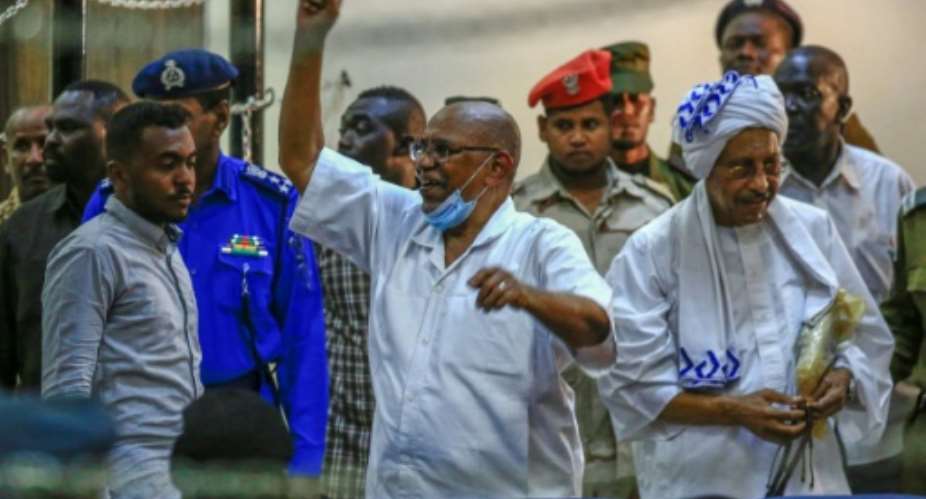 Sudan's ousted president Omar al-Bashir C gestures on arrival for his trial in the capital Khartoum along with 27 co-accused over the 1989 military coup that brought him to power.  By ASHRAF SHAZLY AFP