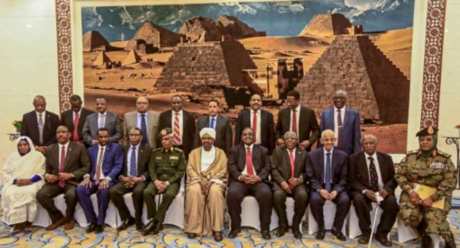 Sudan's President Omar al-Bashir 6th-L, front poses for a group photo with members of his new 20-member cabinet as they take the oath of office at the presidential palace in Khartoum.  By ASHRAF SHAZLY AFP