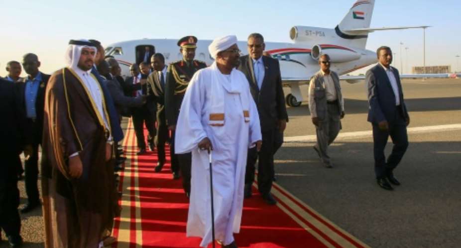 Sudan's President Omar al-Bashir C is received upon his return from Qatar at Khartoum international airport.  By ASHRAF SHAZLY AFP