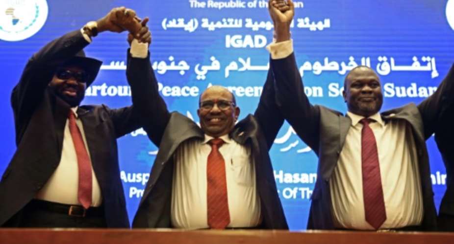 Sudan's President Omar al-Bashir raises the hands of South Sudan's President Salva Kiir  l and South Sudanese rebel leader Riek Machar r after the two arch-foes agreed in Khartoum on June 27 to a 'permanent' ceasefire to take effect within 72 hours.  By ASHRAF SHAZLY AFP
